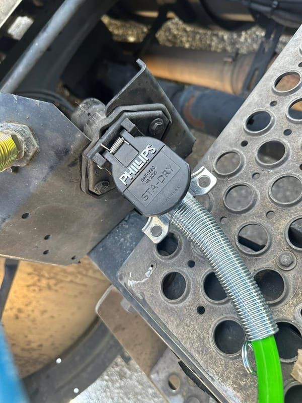 New 7-way trailer plug and coiled cord mounted on a tractor deck plate
