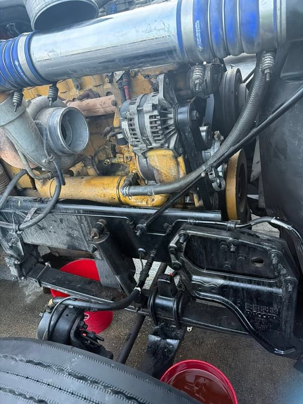 Tractor engine exposed with the hood up during an on site repair