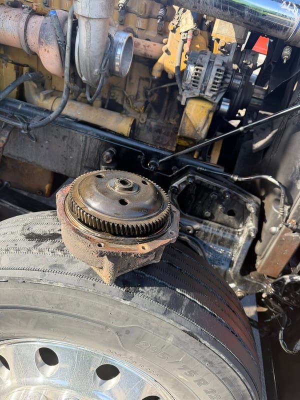 Worn engine part removed and set on a tractor tire during an on site repair