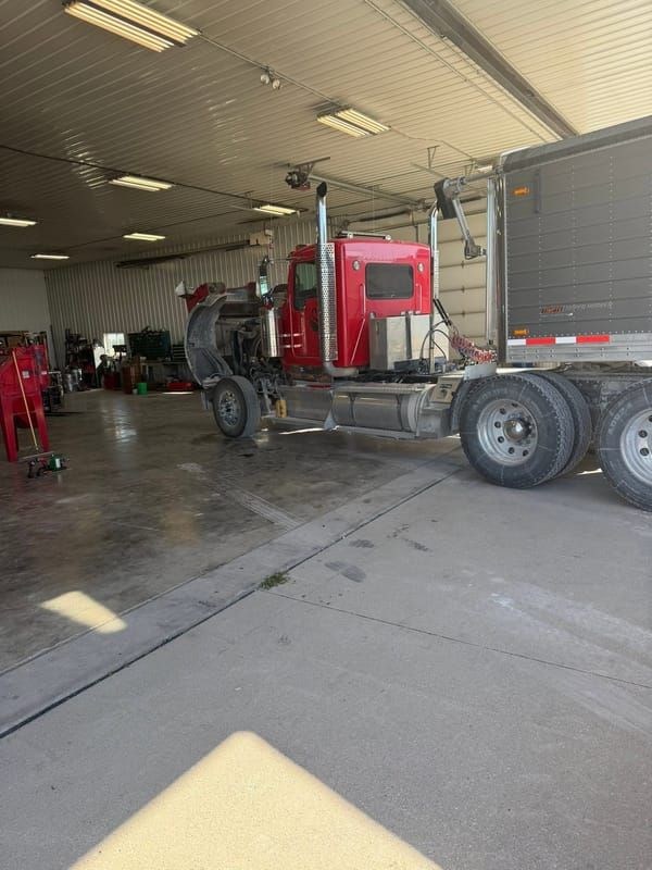 Red semi tractor parked in a service bay